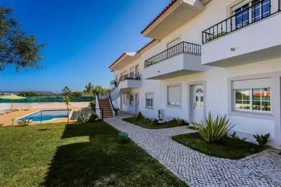 a large white house with a yard and a swimming pool at Charming 2-Bed Apartment in Olhos de Agua in Albufeira