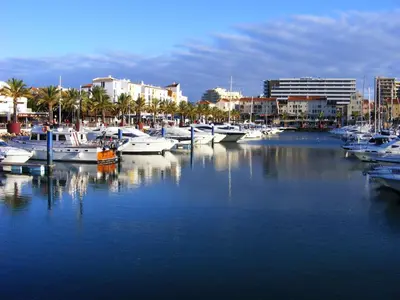 a group of boats docked in a marina with buildings at Beautiful 2-Bed Apartment in Olhos de Agua in Albufeira