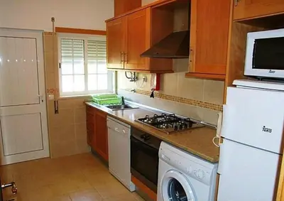 a kitchen with a stove and a washer and dryer at Stunning 1-Bed Apartment in Olhos de Agua in Albufeira