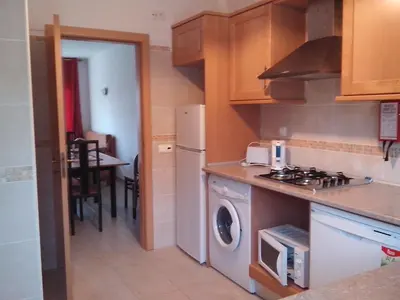 a kitchen with a stove and a washer and dryer at 2 Bed Flat - Sleeps 4 - Parking - Wifi in Albufeira