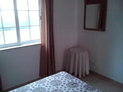 a bedroom with a bed and a mirror and a window at 1 Bed Flat - Sleeps 2 - Parking - Wifi in Albufeira