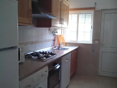 a kitchen with a stove top oven next to a window at Lovely 1-Bedroom Apartment in Olhos de Agua in Albufeira