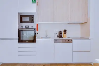 a white kitchen with white cabinets and appliances at AL - Apartamento Pontemira in Quarteira