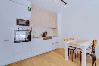 a kitchen with white cabinets and a table with chairs at AL - Apartamento Pontemira in Quarteira