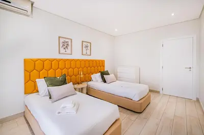 a bedroom with two beds and a orange headboard at Villa Kevin by Atlantic Places in Albufeira