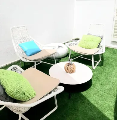 a group of chairs and tables on a green floor at Alojamento local 