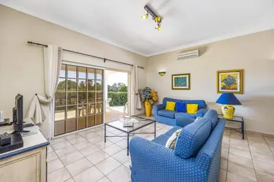a living room with two blue couches and a tv at Villa Casa Sophia by Villa Plus in Olhos de Água