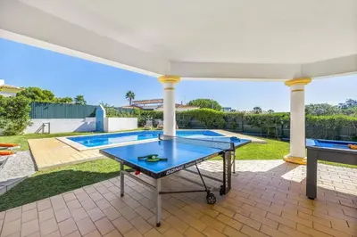 a kitchen with white cabinets and a bowl of fruit on the counter at Villa Casa Sophia by Villa Plus in Olhos de Água