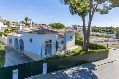 a white house with a tree and a fence at Villa Casa Sophia by Villa Plus in Olhos de Água