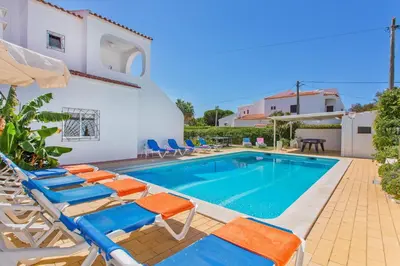 a villa with a swimming pool and lounge chairs at Villa Terra by Villa Plus in Albufeira