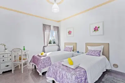 a bedroom with two beds and a dresser at Villa Leonor by Villa Plus in Olhos de Água