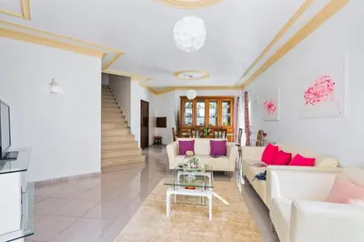 a living room with white furniture and pink pillows at Villa Leonor by Villa Plus in Olhos de Água
