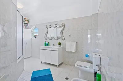a white bathroom with a toilet and a sink at Villa Leonor by Villa Plus in Olhos de Água