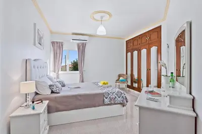 a bedroom with a large bed and two tables at Villa Leonor by Villa Plus in Olhos de Água