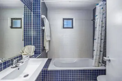 a blue tiled bathroom with a tub and a sink at Villa Sunshine by Villa Plus in Albufeira