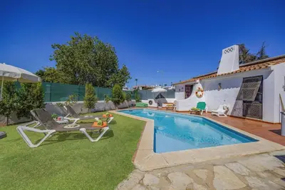 a backyard with a swimming pool with a patio furniture at Villa Sunshine by Villa Plus in Albufeira