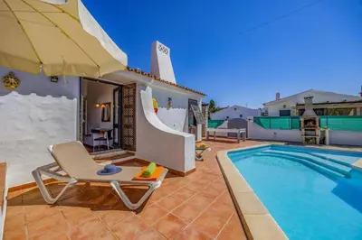 a patio with a chair and a swimming pool at Villa Sunshine by Villa Plus in Albufeira