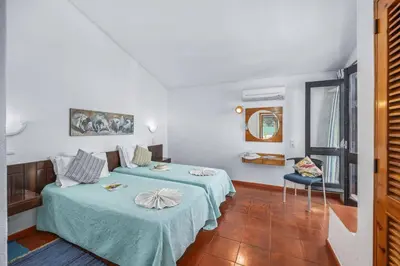 a hotel room with two beds and a mirror at Villa Sunshine by Villa Plus in Albufeira