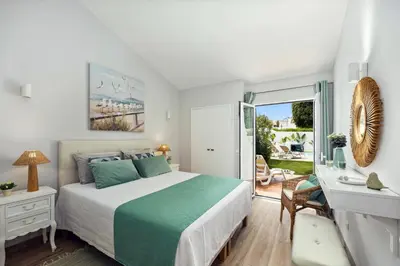 a bedroom with a bed and a desk and a window at Villa Lela by Villa Plus in Albufeira