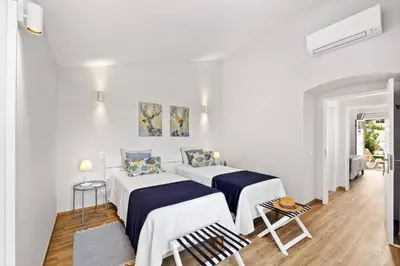 two beds in a room with white walls at Villa Lela by Villa Plus in Albufeira