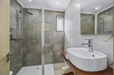 a bathroom with a toilet and a sink and a shower at Villa Pina by Villa Plus in Albufeira