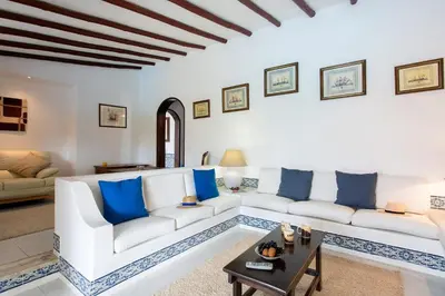 a living room with white furniture and blue pillows at Villa Tupi by Villa Plus in Boliqueime