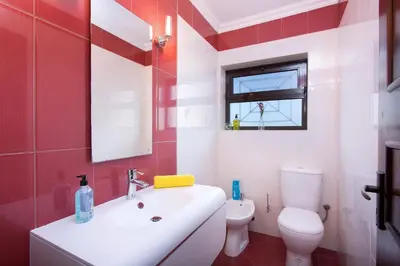 a red and white bathroom with a sink and a toilet at Villa Tupi by Villa Plus in Boliqueime
