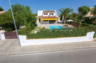 a house with a swimming pool in front of a house at Villa Tupi by Villa Plus in Boliqueime