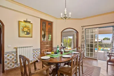 a dining room with a table and chairs at Villa Boavista by Villa Plus in Boliqueime