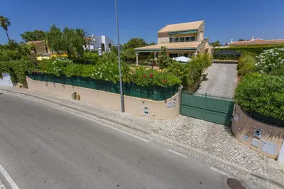 a house with flowers and a road in front of it at Villa Boavista by Villa Plus in Boliqueime