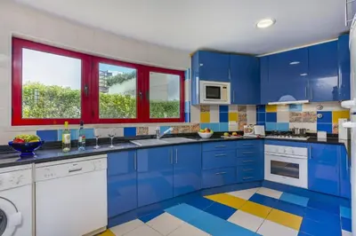 a kitchen with blue cabinets and a colorful floor at Villa Marina View by Villa Plus in Albufeira
