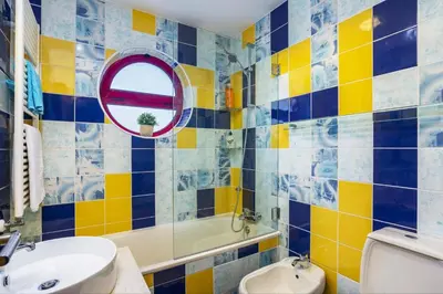 a bathroom with a yellow and blue tiled wall at Villa Marina View by Villa Plus in Albufeira