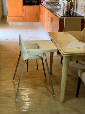 a white chair sitting next to a table in a kitchen at Casa Rústica em Alte - KARMEA HOUSES in Alte