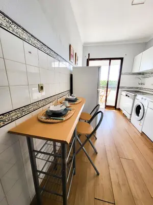 a kitchen with a table and chairs in a room at T1 Tenis Golf Mar- Marina de Vilamoura- Piscina in Vilamoura