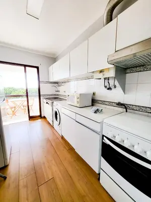 a kitchen with white appliances and a wooden floor at T1 Tenis Golf Mar- Marina de Vilamoura- Piscina in Vilamoura
