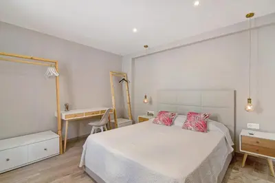 a bedroom with a white bed with two red pillows at Casa Rebelo da Silva in Faro