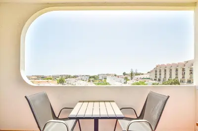 a table and chairs in a room with a large window at SouthView Studio Silchoro AL in Albufeira