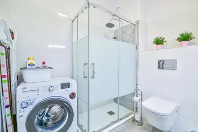 a bathroom with a washing machine in a shower at SouthView Studio Silchoro AL in Albufeira