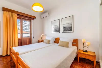 a bedroom with two beds and a window at Ténis Mar F in Albufeira