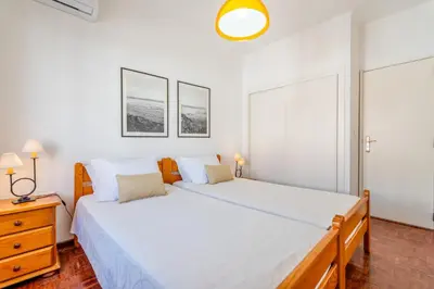 a white bedroom with a large bed and two windows at Ténis Mar F in Albufeira