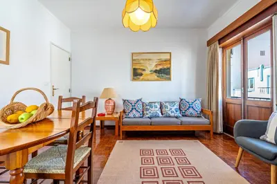 a living room with a table and a couch at Ténis Mar F in Albufeira