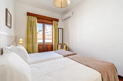 a bedroom with two beds and a window at Ténis Mar F in Albufeira