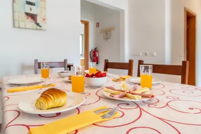 a table with a breakfast of croissants and orange juice at Solário de São José - AD by HelloVacations in Albufeira