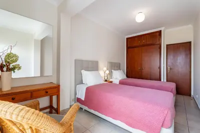 a bedroom with two beds and a table and chairs at Ténis Mar E in Albufeira