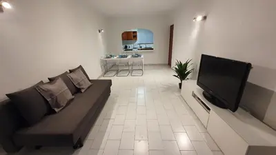 a living room with a couch and a flat screen tv at BeGuest Areias Apartment in Albufeira