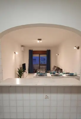 a kitchen with an archway over a counter with dishes at BeGuest Areias Apartment in Albufeira