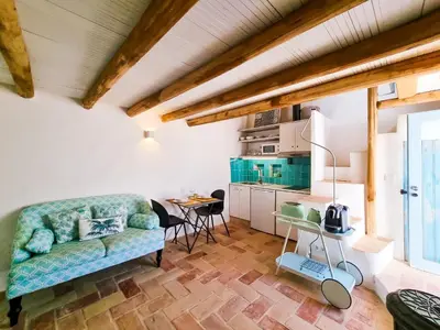 a living room with a couch and a kitchen at FLH Vale Judeu Rustic Mezzanine Cottage II in Loulé