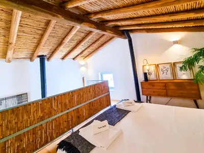 a room with a table and chairs in it at FLH Vale Judeu Rustic Mezzanine Cottage II in Loulé