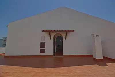 a white building with an archway and a doorway at Apartamento Olhos D'Água VistaBella in Olhos de Água