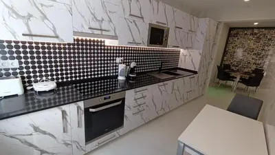a kitchen with black and white tile on the wall at New Appartment! Albufeira in Albufeira
